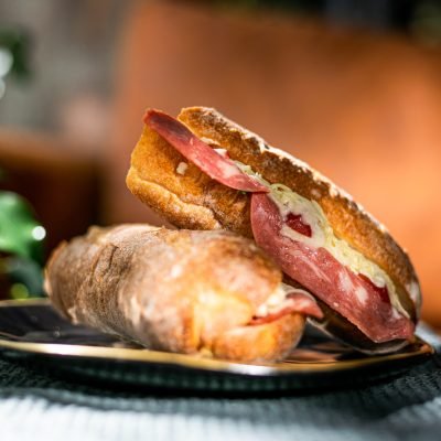 Side view of sandwichs with sausage and cheese on plate